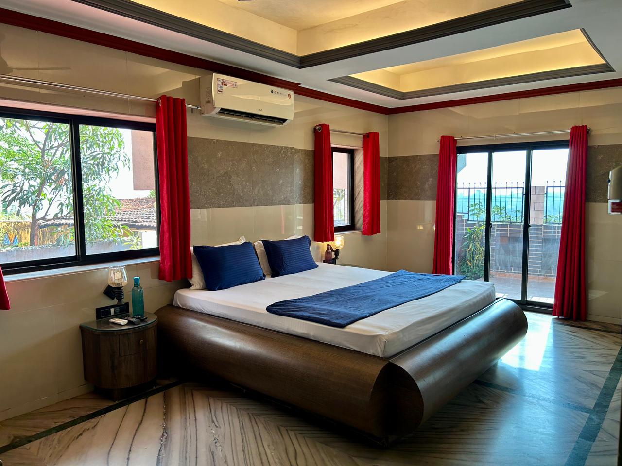 Bedroom with balcony doors at Hill Top Villa in Mapusa