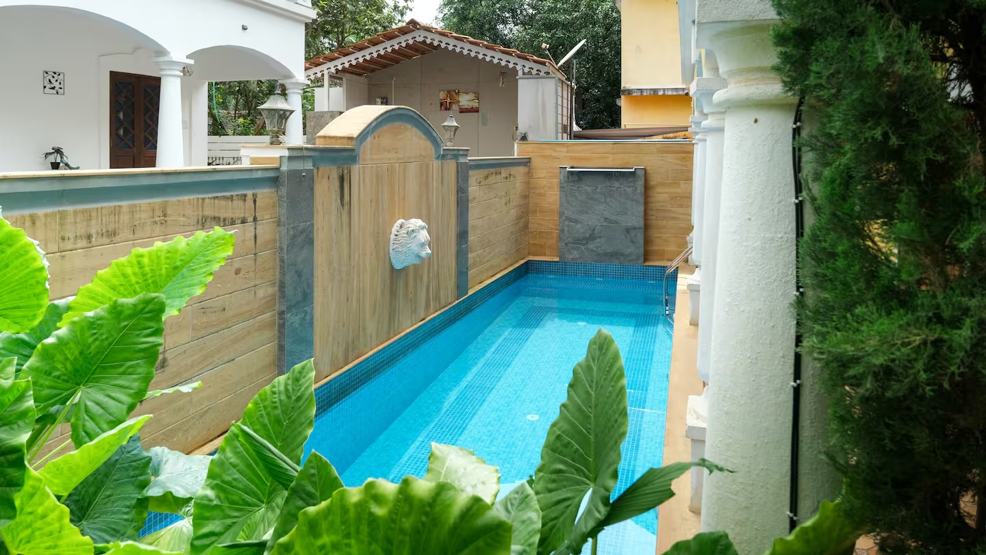 Pool surrounded by greenery at House of Legends Villa, Saligao